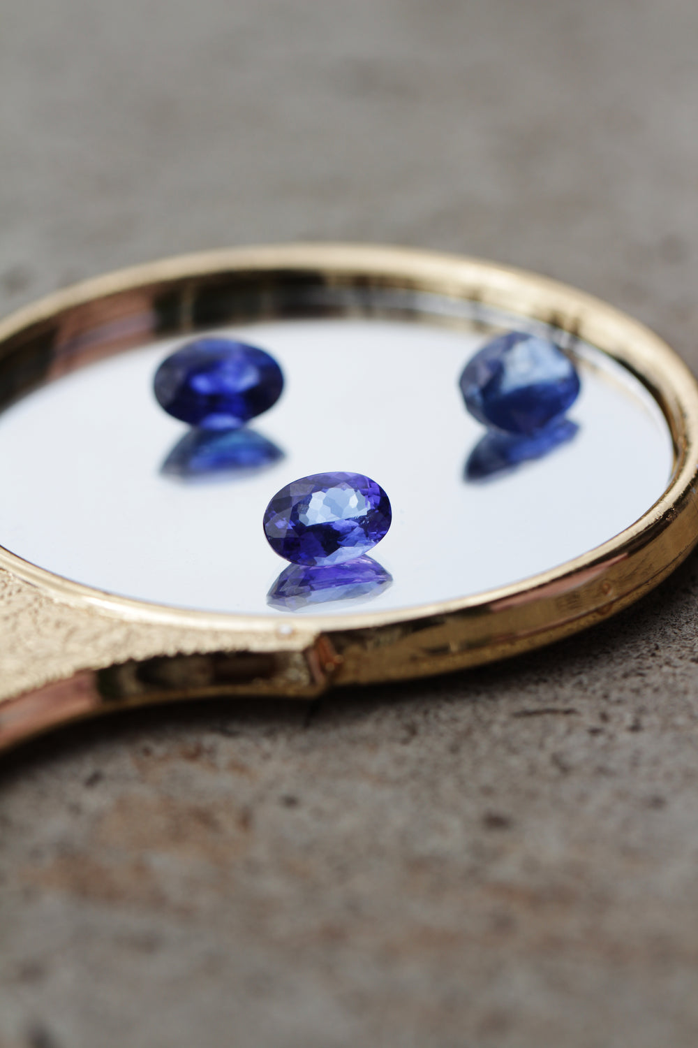 Natural blue sapphires (Neelam) on a gold mirror